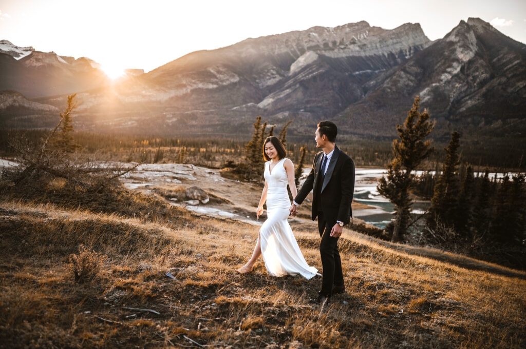 Bride and Groom walking on the Overlander Trail during sunset in Jasper